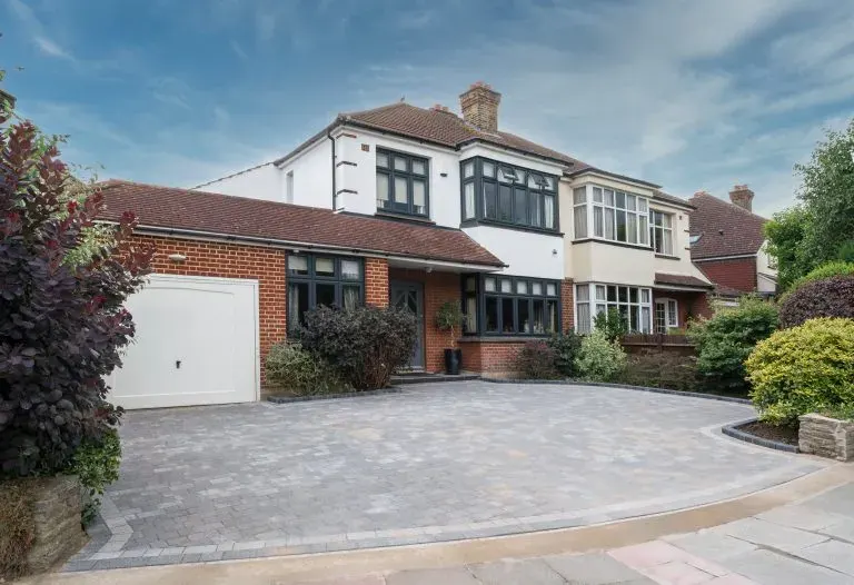 Grey block paved driveway with charcoal border outside a semi-detached home